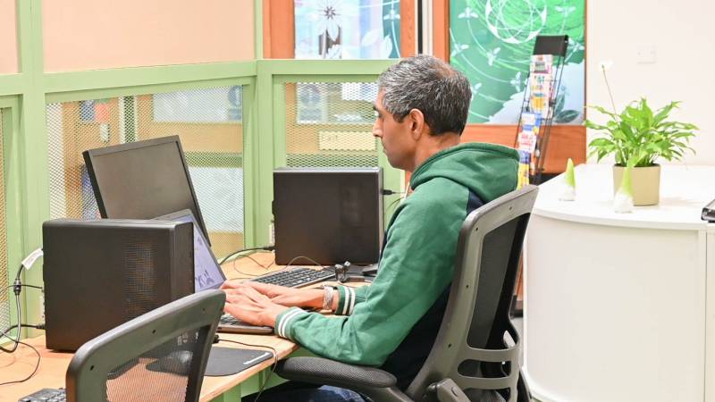 A man working at the new digital skills space in the Green Community Hub